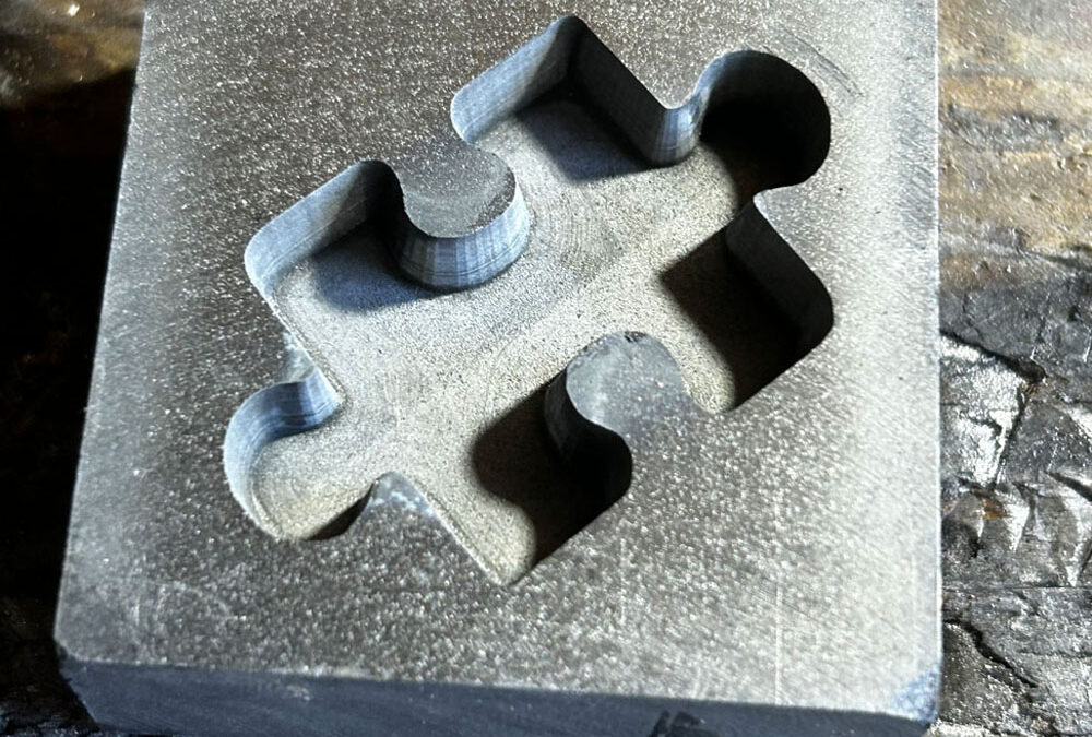 Why is it critical to pre-heat a graphite mould before pouring molten metal into it?
